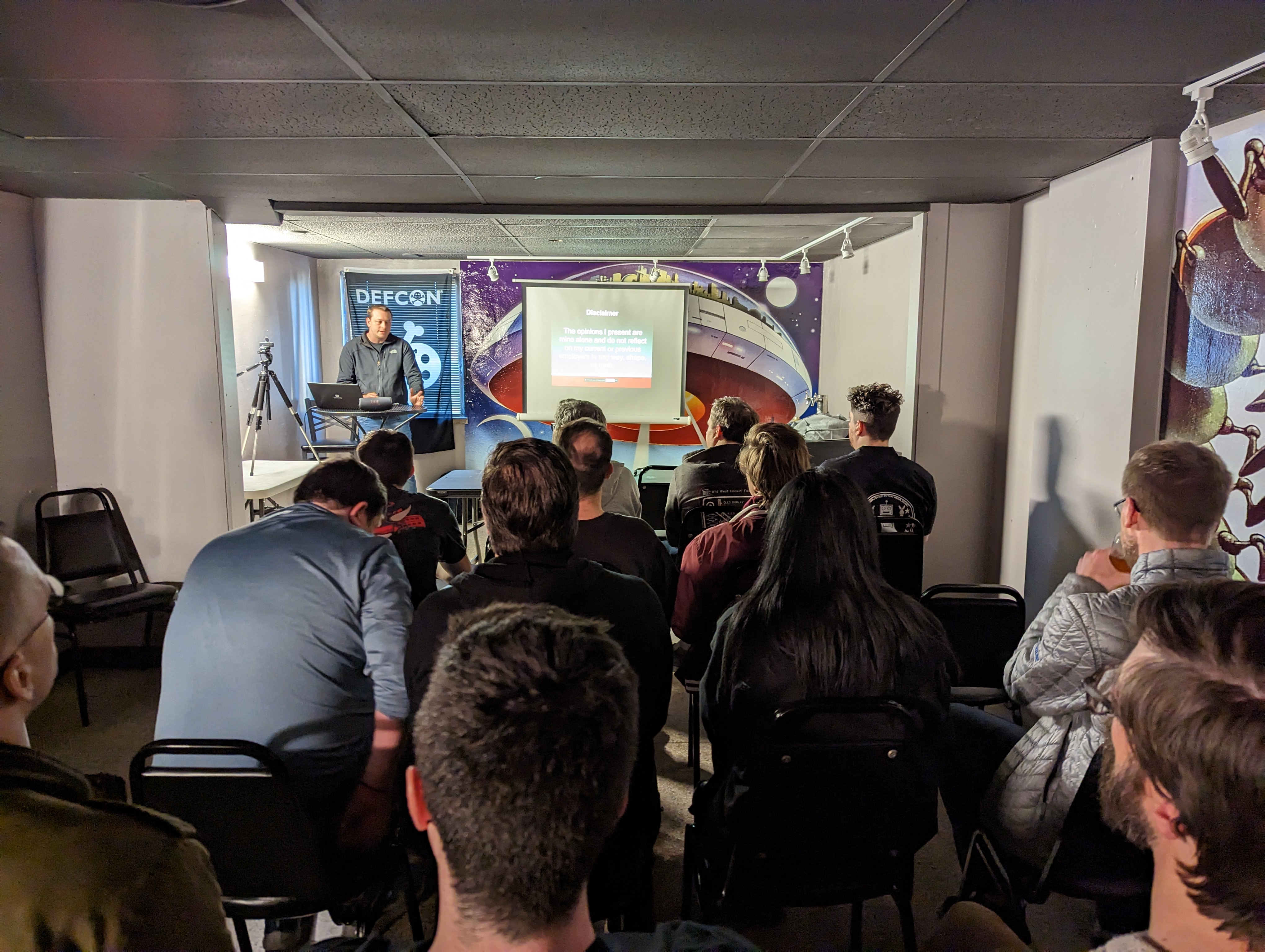 A speaker presenting to a full room at a DC608 meetup
